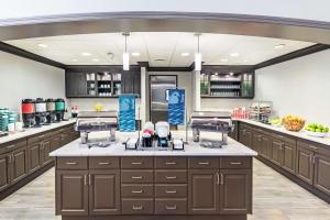 a large kitchen with brown cabinets and a large counter at Homewood Suites by Hilton Shreveport in Shreveport