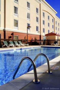 a swimming pool in a hotel with chairs and a building at Hampton Inn Shreveport-Airport in Shreveport