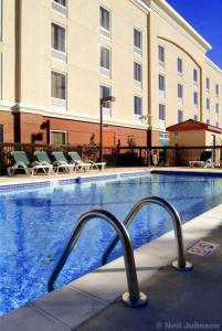 una piscina en un hotel con sillas y un edificio en Hampton Inn Shreveport-Airport, en Shreveport