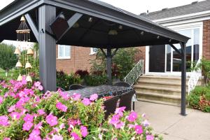 a picnic table under a black umbrella in a garden at As You Like It Bed and Breakfast in Niagara-on-the-Lake