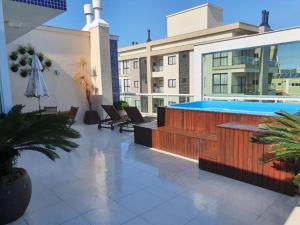 un patio con piscina en la parte superior de un edificio en Cobertura com piscina aquecida Mariscal 205 Palm, en Bombinhas