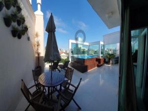 un patio con mesa, sillas y piscina en Cobertura com piscina aquecida Mariscal 205 Palm, en Bombinhas