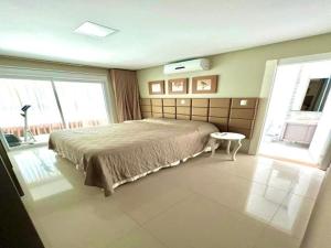 una camera da letto con un letto e due finestre di ANSNEGOCIOS DUPLEX FRENTE PRAIA MARISCAL 205 Palm a Bombinhas Altre 16 foto