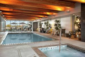 a swimming pool in a hotel with tables and chairs at Home2 Suites by Hilton West Valley City in West Valley City
