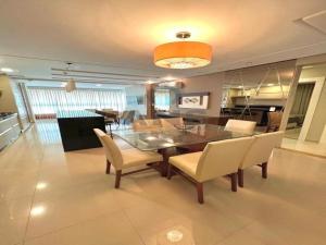 una sala da pranzo con tavolo e sedie in vetro di ANSNEGOCIOS DUPLEX FRENTE PRAIA MARISCAL 205 Palm a Bombinhas