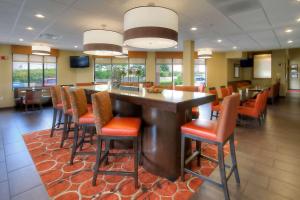 a restaurant with a large bar with orange chairs at Hampton Inn Salt Lake City-Layton in Layton