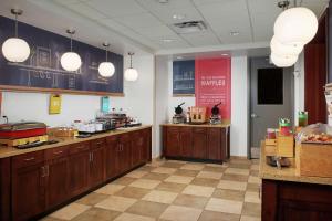 a large kitchen with wooden cabinets in a restaurant at Hampton Inn and Suites Salem in Salem