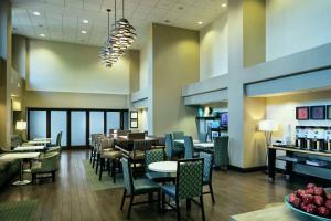 a restaurant with tables and chairs and a bar at Hampton Inn & Suites Arroyo Grande in Arroyo Grande