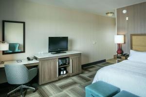 a hotel room with a bed and a flat screen tv at Hampton Inn & Suites Arroyo Grande in Arroyo Grande