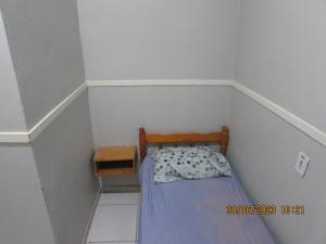 Dormitorio pequeño con cama pequeña y mesita de noche en POUSADA ECONOMICA PORTO, en Porto Alegre