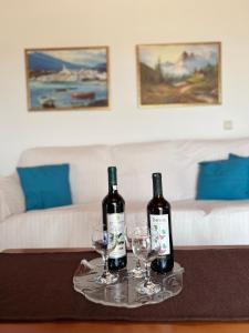 ラヴリオにあるLuxury Country Homeのワイン2本、テーブル上のグラス2杯