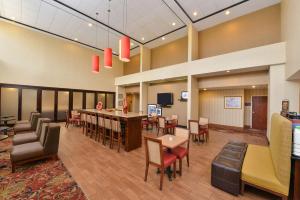 a large lobby with a dining room and a bar at Hampton Inn Selma in Selma