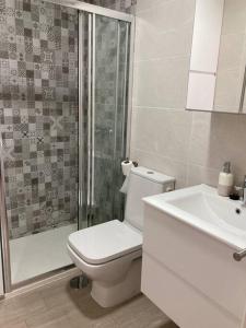 een badkamer met toilet, douche en wastafel bij Apartamento Rota Progreso 5 in Rota +7 foto's