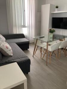 een woonkamer met een bank en een glazen tafel bij Apartamento Rota Progreso 5 in Rota