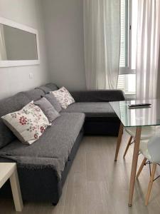 een woonkamer met een bank en een glazen tafel bij Apartamento Rota Progreso 5 in Rota