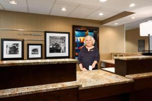 a man standing behind a counter in a hotel room at Hampton Inn Santee-I-95 in Santee