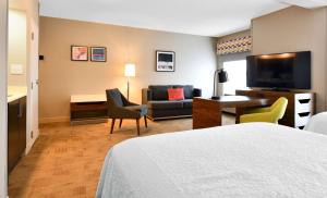 a hotel room with a bed and a living room at Hampton Inn Santee-I-95 in Santee