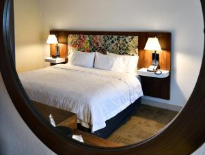 a bedroom with a bed and two lamps and a mirror at Hampton Inn Santee-I-95 in Santee