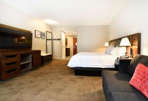 a hotel room with a bed and a couch at Hampton Inn Santee-I-95 in Santee
