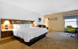 a hotel room with a large bed and a chair at Hampton Inn Santee-I-95 in Santee