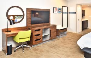 a bedroom with a desk with a television and a chair at Hampton Inn Santee-I-95 in Santee