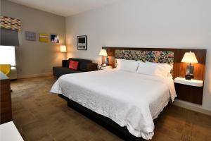 a hotel room with a large bed and a couch at Hampton Inn Santee-I-95 in Santee