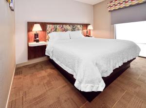 a bedroom with a large bed with a white bedspread at Hampton Inn Santee-I-95 in Santee