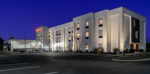 a white building with a parking lot in front of it at Hampton Inn - Springfield in Springfield