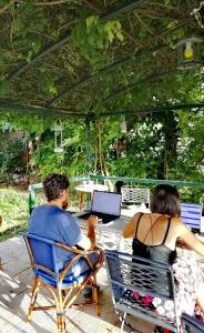 a man and a woman sitting in chairs with a laptop at Villa Ettore in Gardeládes