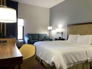 Habitación de hotel con cama y sofá en Hampton Inn by Hilton Spring Hill, en Timber Pines