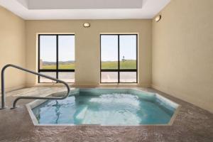 a jacuzzi tub in a room with windows at Hampton Inn Spearfish in Spearfish