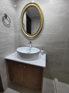 baño con lavabo y espejo en la pared en La maison d Aspasia, en Kamilari