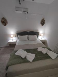 a bedroom with a large bed with two towels on it at La maison d Aspasia in Kamilari
