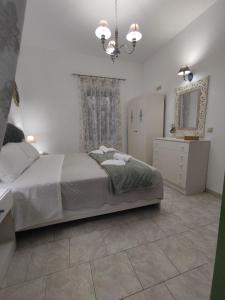 1 dormitorio con cama, tocador y espejo en La maison d Aspasia, en Kamilari