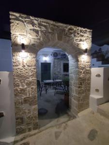 un arco in pietra con tavolo in una stanza di La maison d Aspasia a Kamilari