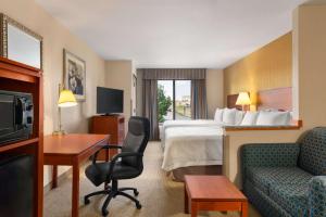 a hotel room with a bed and a desk and chair at Hampton Inn Spearfish in Spearfish