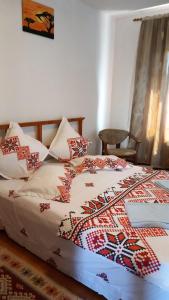 1 dormitorio con cama con edredón y almohadas en CASA ADELA, en Tulcea