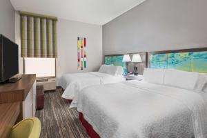 a hotel room with two beds and a flat screen tv at Hampton Inn Ellenton/Bradenton in Ellenton