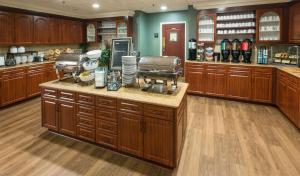 Homewood Suites by Hilton Sarasota في ساراسوتا: مطبخ كبير مع دواليب خشبية وقمة كونتر