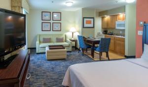 um quarto de hotel com uma cama e uma sala de estar em Homewood Suites by Hilton Sarasota em Sarasota