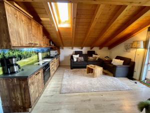 eine Küche und ein Wohnzimmer mit einem Sofa und einem Tisch in der Unterkunft Gipfelglück in Reit im Winkl