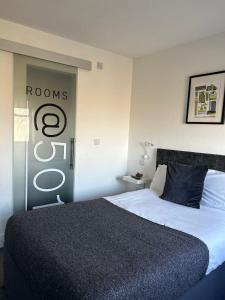 a bedroom with a bed with a sign on the wall at Rooms Kingswood in Bristol