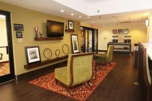 a waiting room with chairs and a flat screen tv at Hampton Inn Sumter in Sumter