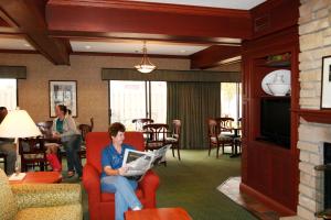 a woman sitting on a chair in a living room with a laptop at Hampton Inn South Haven in South Haven