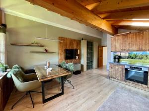 a living room with a table and a kitchen at Gipfelglück in Reit im Winkl