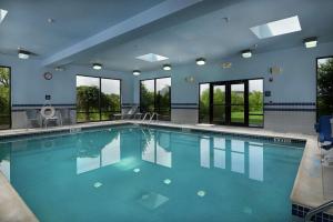 a large pool with blue water in a building with windows at Hampton Inn Shrewsbury in Shrewsbury