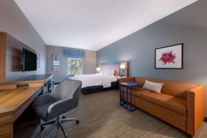 ein Hotelzimmer mit einem Sofa und einem Bett in der Unterkunft Hampton Inn Saint Robert in Saint Robert