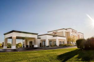 a large white building with a green lawn at Hampton Inn Plover-Stevens Point in Plover