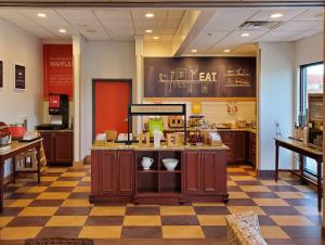 a restaurant with a counter in the middle of a room at Hampton Inn Plover-Stevens Point in Plover