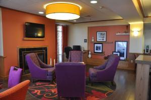 a waiting room with purple chairs and a fireplace at Hampton Inn Stony Creek in Stony Creek